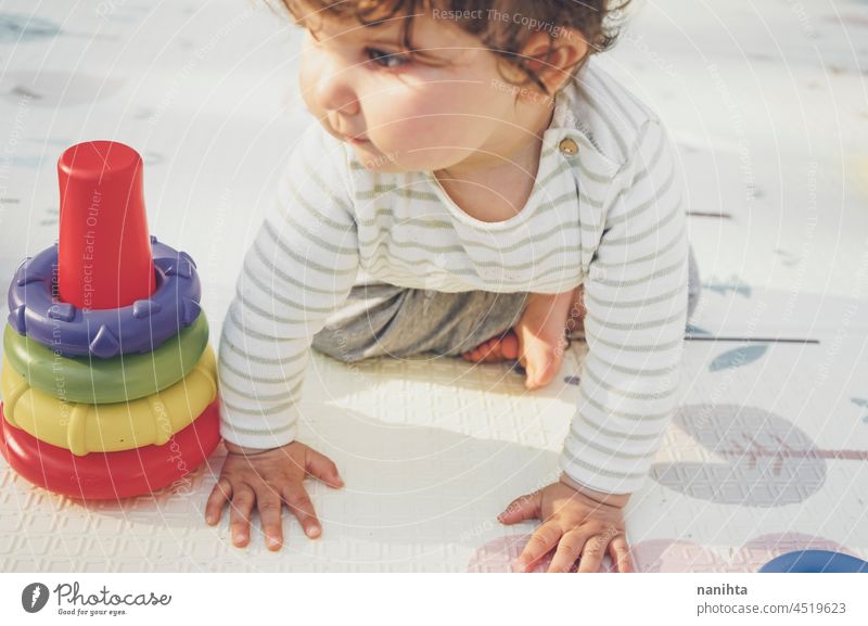 Kleines Baby genießt den Tag beim Spielen mit ihrem Spielzeug spielerisch krabbeln kriechend Säuglingsalter Elternschaft Kleinkind Glück Fröhlichkeit genießen