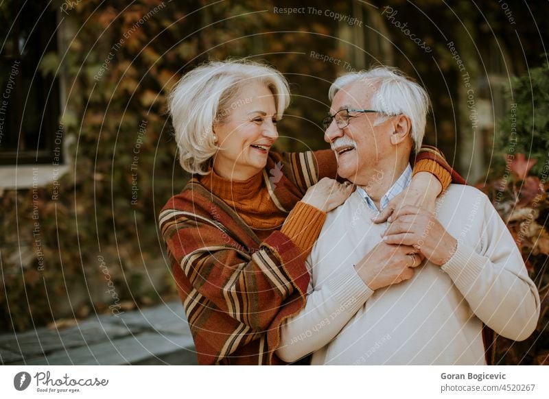 Älteres Paar, das sich im Herbst im Park umarmt alt Senior Liebe Frau Mann Lächeln Ehemann in den Ruhestand getreten Ehefrau im Freien Romantik reif lässig