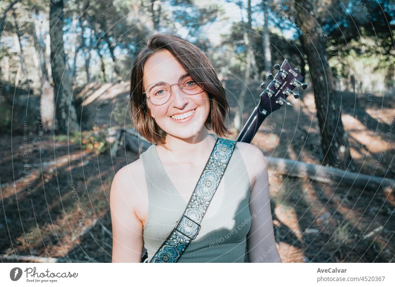 Junges Hipster-Mädchen mit Brille lächelt in die Kamera mit einer E-Gitarre auf dem Rücken, Studie Musikkonzepte, Kopie Raum, soziale Netzwerke, Selbstverbesserung