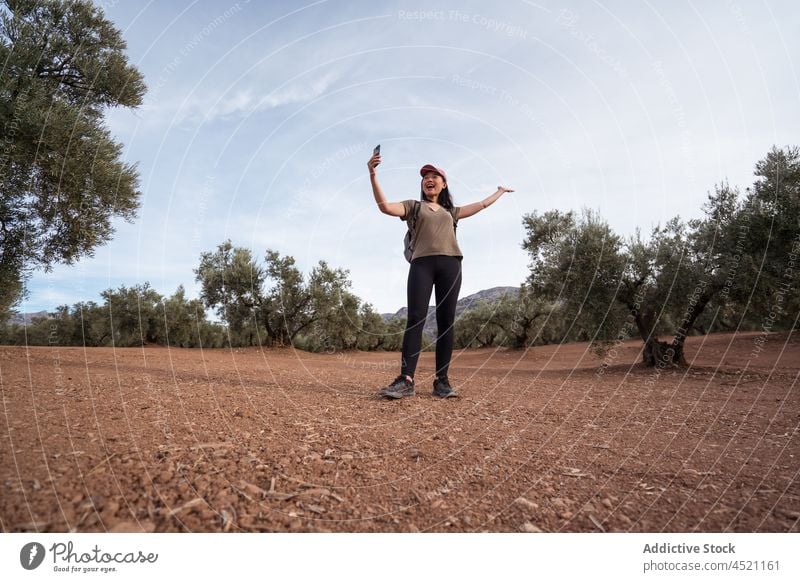 Fröhliche asiatische Frau macht Selfie im Olivenhain Smartphone oliv Baum Hain Schonung Fotografie einfangen Landschaft Ackerland Apparatur Mobile Gerät Sommer