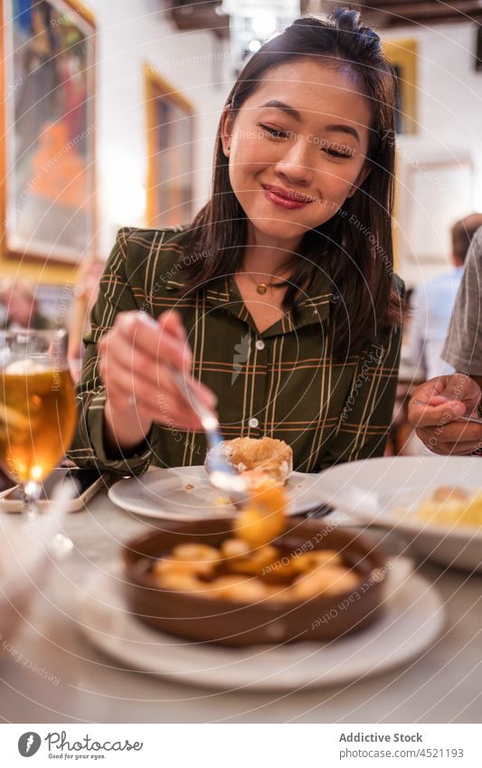 Glückliche junge asiatische Frau isst Garnelen im Restaurant essen Granele Lächeln hungrig lecker Mahlzeit Lebensmittel Inhalt positiv Zusammensein ethnisch