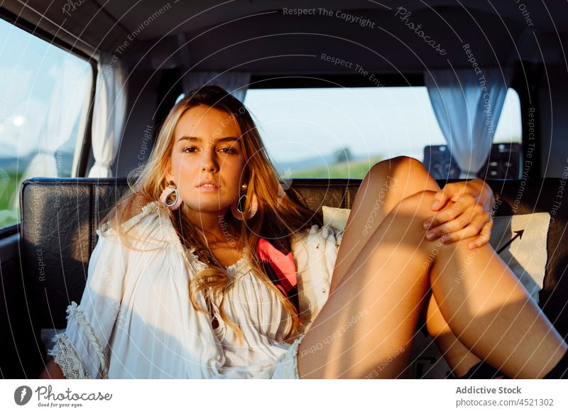 Attraktives blondes Mädchen in einem Oldtimer-Van und auf dem Sitz liegend an einem sonnigen Tag attraktiv sinnlich hübsch Frau Kaukasier Sitzen entspannt