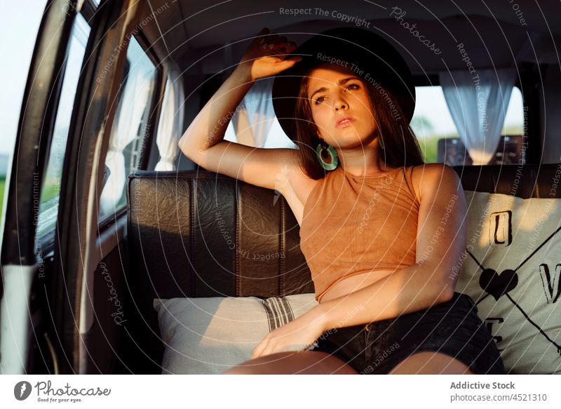 Attraktives brünettes Mädchen in einem Oldtimer-Van und sitzt auf dem Sitz an einem sonnigen Tag attraktiv sinnlich hübsch Frau Hut Kaukasier Sitzen Lügen