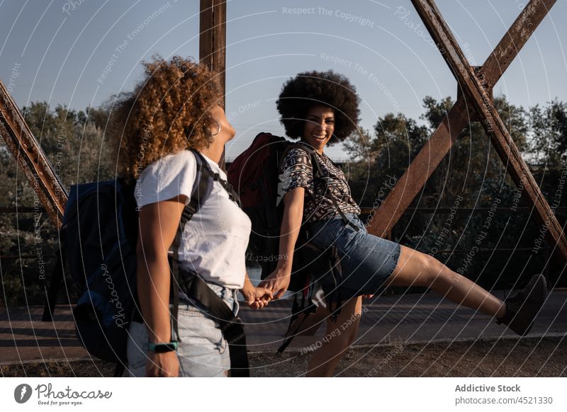 Schwarze Freunde halten sich auf einer alten Brücke an den Händen Frauen Lachen Freude Wanderung Glück Händchenhalten Spaziergang Spaß kuscheln bester Freund