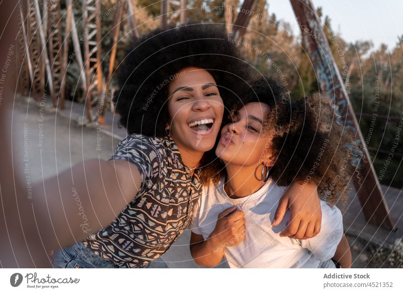 Positive schwarze Frauen, die sich umarmen und ein Selfie machen bester Freund schmollende Lippen Spaß haben Freundschaft Bonden Umarmung Freude Sonnenuntergang