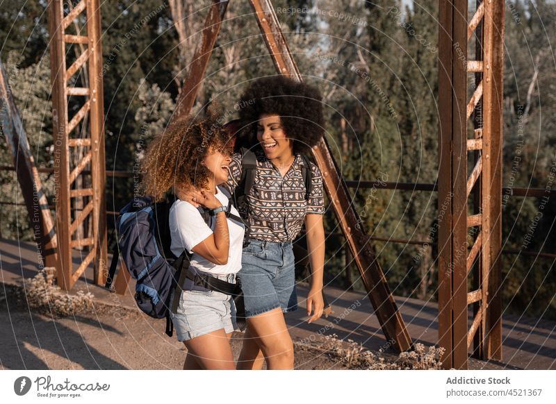 Schwarze Freunde umarmen sich auf einer alten Brücke Frauen Lachen Streicheln Freude Umarmung Wanderung Glück Spaß kuscheln bester Freund sorgenfrei Abenteuer