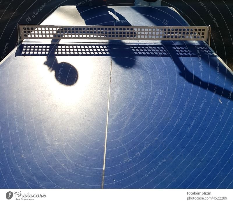 Tischtennis: Schatten einer Person mit Schläger auf der blauen Tischtennisplatte Tischtennisschläger Tischtennisnetz Tischtennistisch Tischtennisspiel Netz