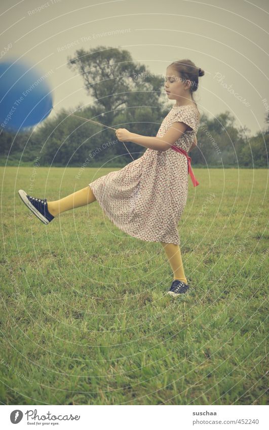 der blaue ballon .. Kind Mädchen Kleid Arme Beine Fuß Hand Außenaufnahme Spielen Wiese Gras Luftballon retro junges Mädchen Kindheit Verspieltheit Familienfeier