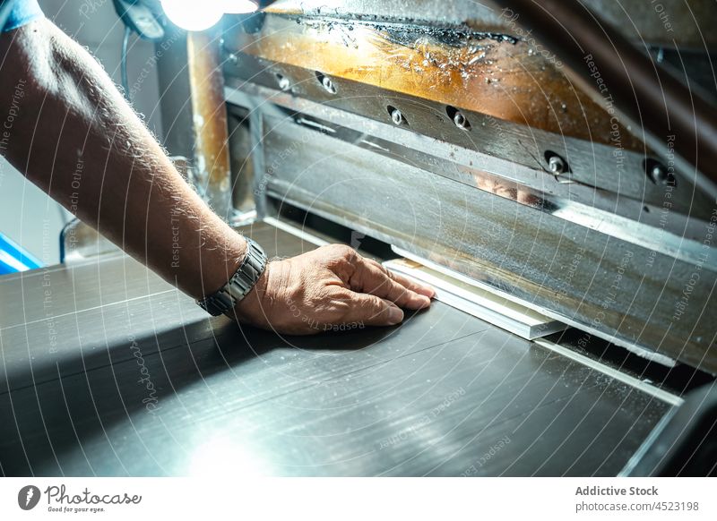 Erntehelferin an einer großen Druckmaschine Mann arbeiten Papier drucken Prozess Fabrik Kunstgewerbler Werkstatt Inszenierung Lampe professionell Maschine Schot
