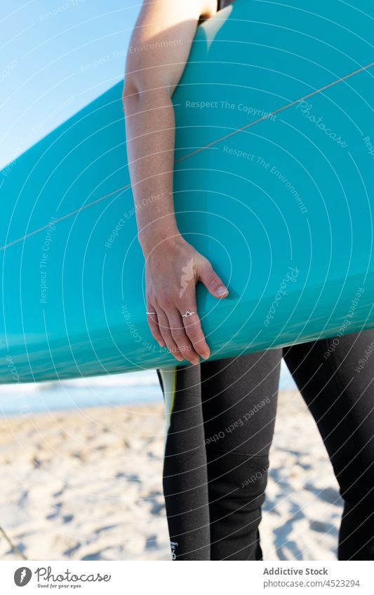 Anonyme Frau mit Surfbrett am Meeresufer Surfer MEER tropisch Strand Fuß winken schäumen sorgenfrei Aktivität Neoprenanzug Körperteil Brandung Küste Ufer Wasser