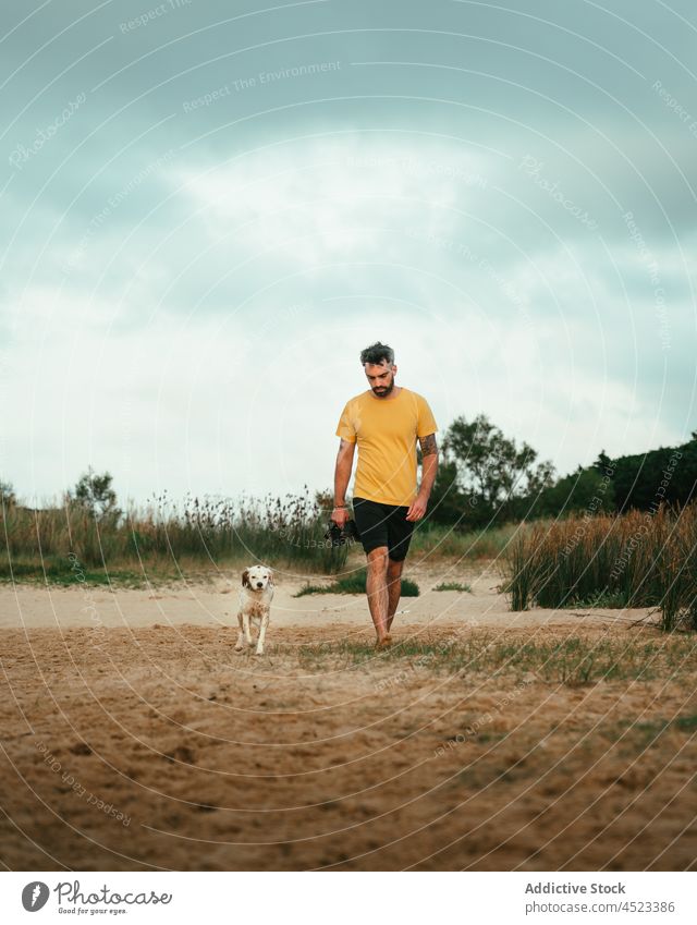 Mann geht mit Hund an der Küste spazieren Besitzer Tier Ufer Haustier Natur Strand heimisch Flussufer Eckzahn Säugetier Sommer Stammbaum Kreatur Umwelt