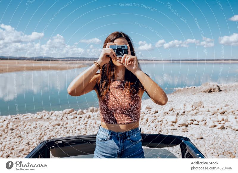 Junge Frau fotografiert mit einer alten Kamera Fotoapparat fotografieren altehrwürdig einfangen PKW Küste altmodisch Teich Natur Verkehr Umwelt See Oldtimer