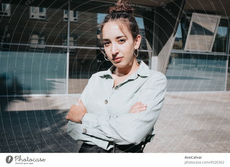 Junge arabische Frau, Unternehmerin, verschränkt die Arme und schaut ernst in die Kamera, im Freien. Business-Konzept, Porträt von Büro Geschäftsfrau jung