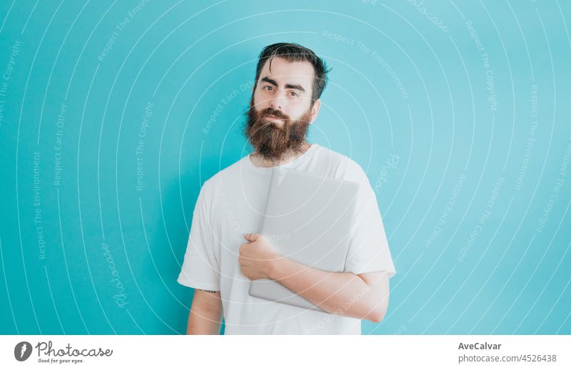 Junge Hipster bärtigen Mann hält einen Laptop, Kopie Raum, weichen blauen abnehmbaren Hintergrund, minimal basic, Student, Unternehmer Konzept, weißes Hemd Raum