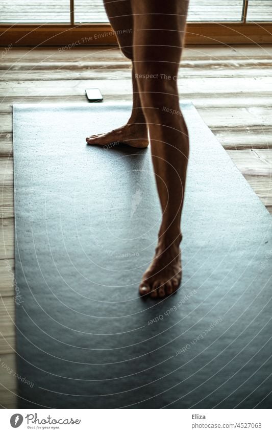 Männerbeine auf einer Yogamatte yogaübung Mann Zuhause nackt Lifestyle Handy Telefon Fitness Holzboden schwarz Yogastellung Körper Mensch Beine stehen
