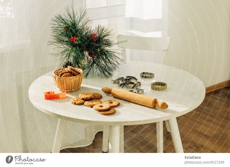 Weihnachts- oder Neujahrsgebäck auf einem mit Tannenzweigen geschmückten Tisch. Weihnachten, Lebkuchen, Formen für die Festtagsbäckerei Weihnachtsplätzchen