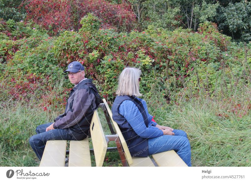 dicke Luft - Mann und Frau sitzen Rücken an Rücken auf zwei Bänken  in der Natur Mensch Senior Seniorin draußen Meinungsverschiedenheit Streit Ignoranz Missmut