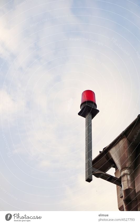 rote Warnleuchte an der Ecke eines Gebäudes neben der Dachrinne / Alarmanlage / Schutzmaßnahme Hausecke Leuchte Signallampe Himmel Dekowolken Technik Sicherheit
