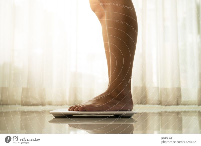 Junge Frau steht auf einer digitalen Waage asiatisch Gleichgewicht Barfuß Körper Pflege Kaukasier Gegenüberstellung Konzepte Zählen Diät älter Fett Fuß Stock