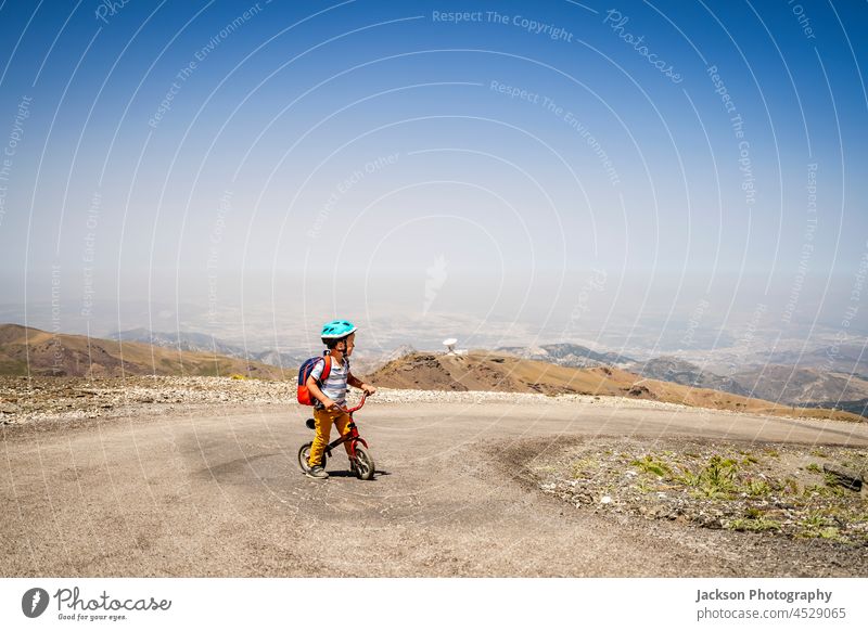 Kleiner Junge fährt auf seinem ersten Fahrrad bergauf in den Bergen der Sierra Nevada, Spanien Kind Sport Wanderung Höhe Ausdauer Top Stehen Spaß Kaukasier