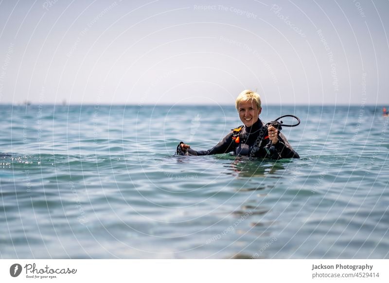 Glückliche Frau, die sich auf das Tauchen im Mittelmeer vorbereitet Sporttauchen Sinkflug offenes Wasser MEER Andalusia genießen Zeichen OK Flossen Abenteuer