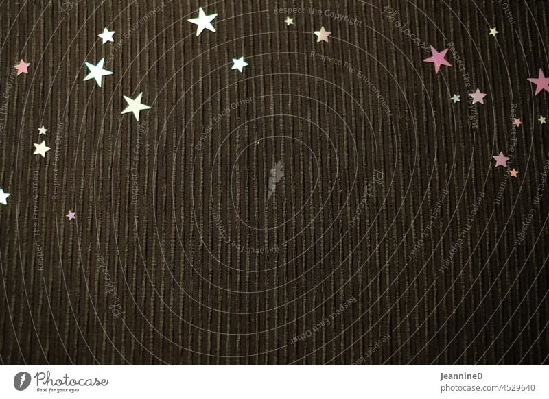Sternenpailetten auf schwarzem Stoff Pailetten Tischset Vogelperspektive Textfreiraum unten Textfreiraum Mitte Flatlay Hintergrund neutral