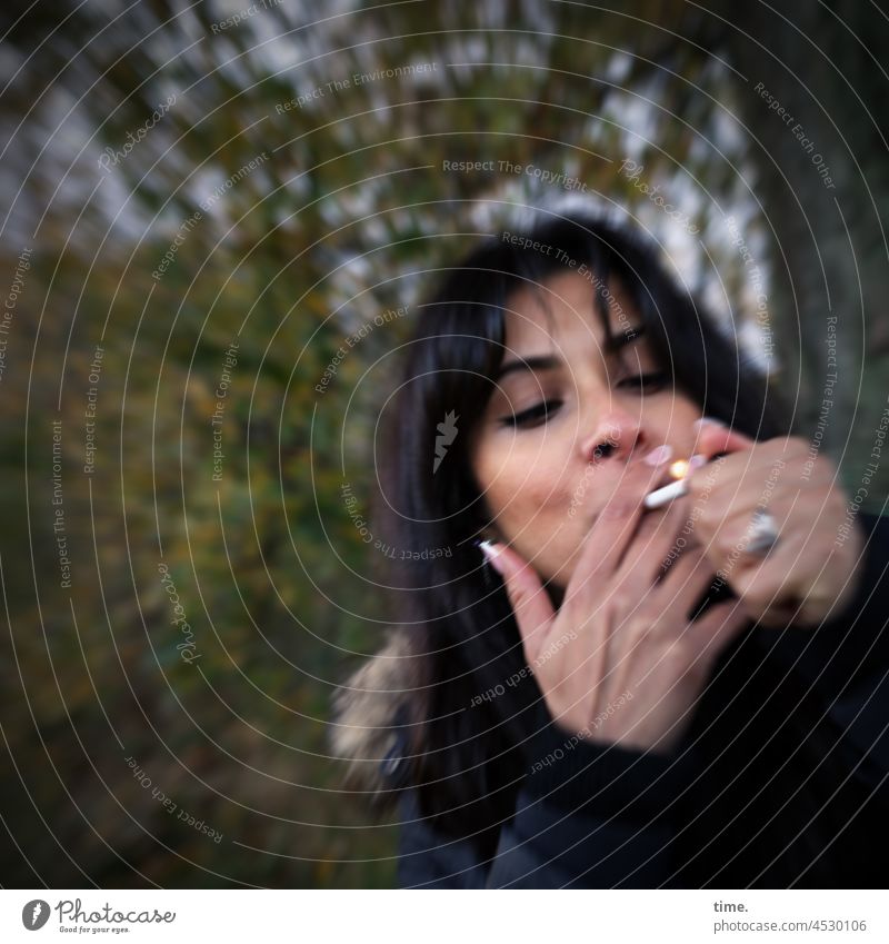Estila frau rauchen zigarette dunkelhaarig langhaarig baum wald halten anzünden fokussieren konzentration
