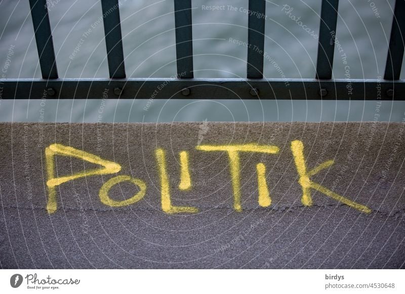Politik , gelber Schriftzug auf einer Brücke Wort Politik & Staat Graffiti Buchstaben Schriftzeichen Parteien Regierung Politisch Brüstung Wasser politisch