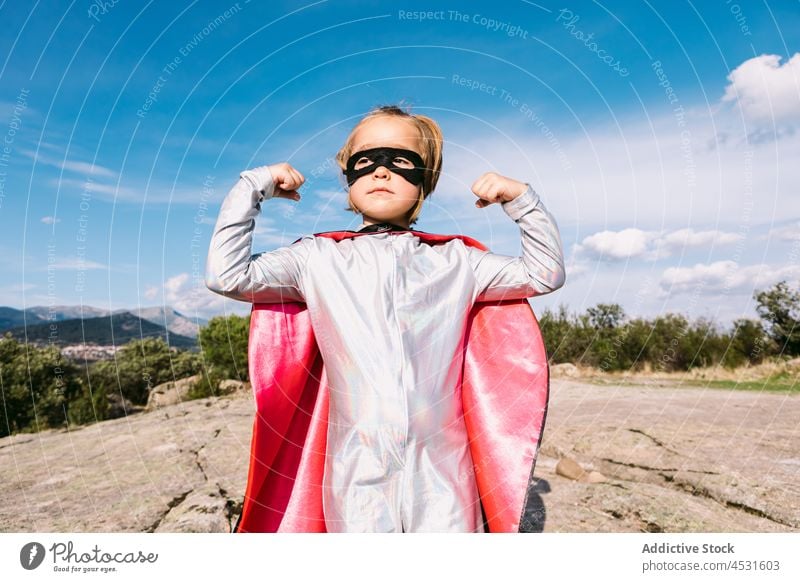 Mutige Superheldin im Kostüm zeigt Muskeln Mädchen Faust stark Körperhaltung retten Kraft behüten Held Stärke selbstbewusst Inspiration Landschaft Verteidigung