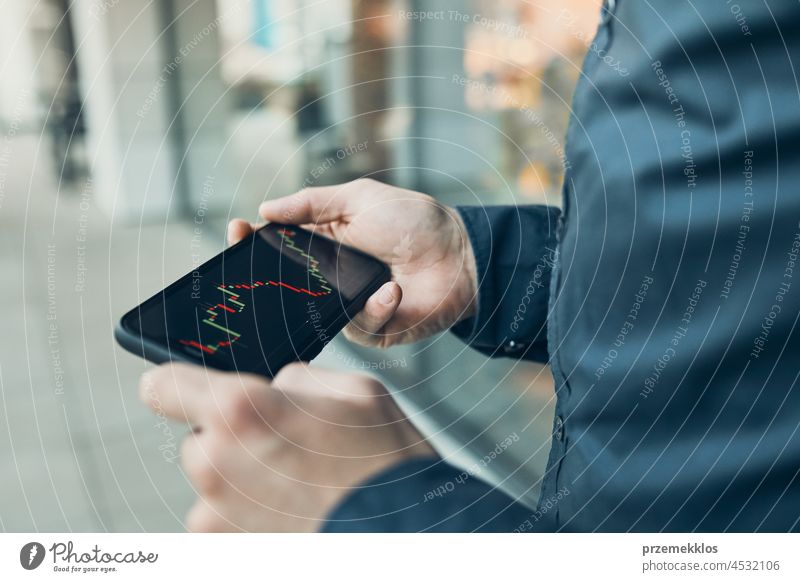 Mann, der in den Aktien- und Kryptowährungsmarkt investiert, indem er die Investitionsanwendung auf seinem Smartphone nutzt Brühe Markt Investierung Handel