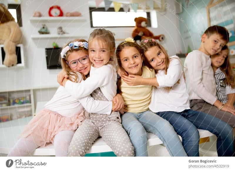 Eine Gruppe von Kindergartenkindern sitzt und hat Spaß jung Glück Junge niedlich Lächeln Menschengruppe Kindheit Vorschulkind Spielzimmer Bursche heiter Freunde