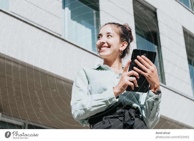 Junge arabische Frau Unternehmerin Frau lächelnd, mit einem Tablet für digitale Zwecke, im Freien. Blick nach links mit Kopie Raum, Business-Konzept, Porträt des Büros