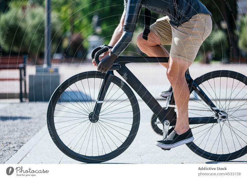 Anonymer Mann mit bionischem Arm fährt Fahrrad in der Stadt künstlich Arme Prothesen Handicap Prothetik Mitfahrgelegenheit Großstadt Bionik männlich Straße