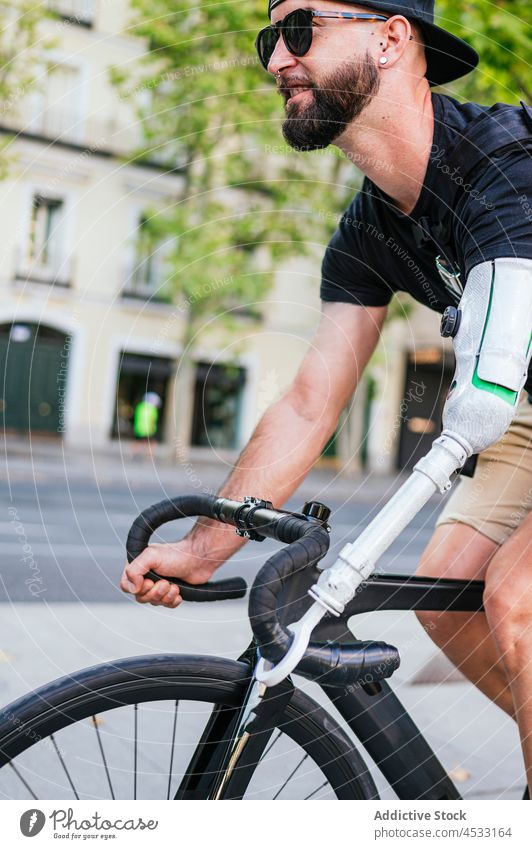 Mann mit bionischem Arm fährt Fahrrad in der Stadt künstlich Arme Prothesen Handicap Prothetik Mitfahrgelegenheit Großstadt Bionik männlich Straße Radfahrer