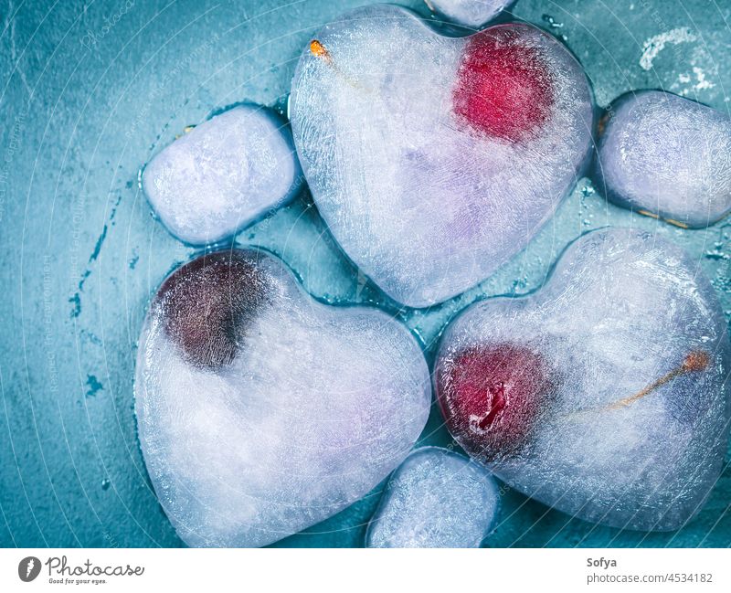 Eiswürfel in Herzform mit gefrorener Kirsche Liebe Frucht Beeren Sommer dunkel kalt erfrischend Lavendel Sirup Hintergrund Textur Form Valentinsgruß Tag
