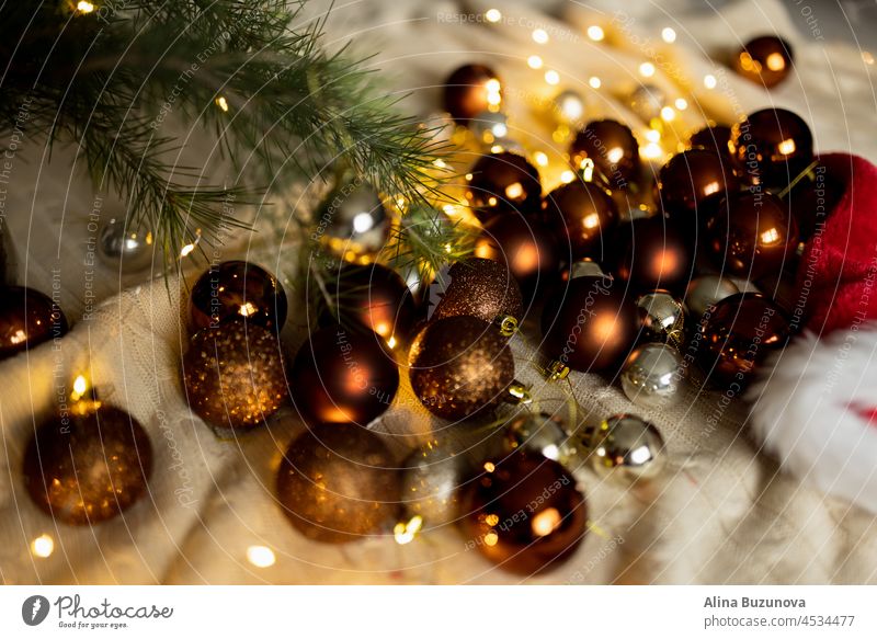 Weihnachtsferien Hintergrund mit braunen und goldenen Kugeln und Girlande Licht auf gemütliche Strickdecke Weihnachten Neujahr Feier Dekoration & Verzierung