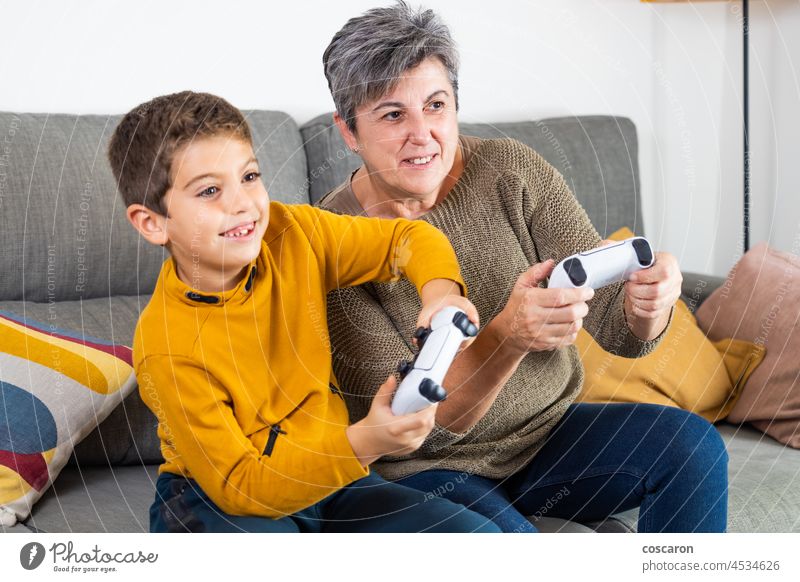 Kleiner Junge und seine Großmutter spielen Videospiele Altersgeneration Unschärfe Kaukasier Kind Konkurrenz Konsole elektronisch Grundschulalter Emotion