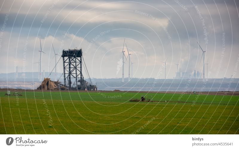 Schaufelradbagger im Braunkohlentagebau Garzweiler2, im Hintergrund ein Braunkohlenkraftwerk und Windräder Fossile Energie Braunkohlenbagger CO2-Ausstoß