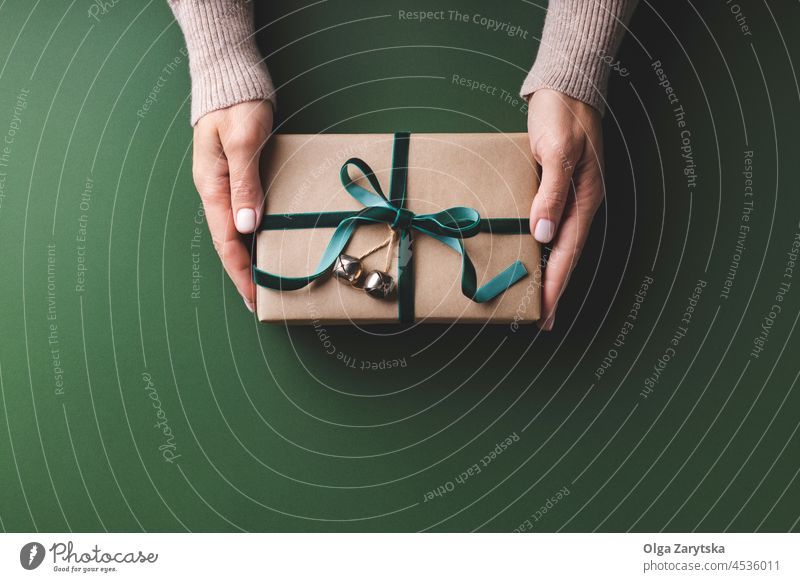 Weibliche Hände halten Weihnachtsgeschenkbox. Weihnachten Geschenk Kasten Hand grün eingewickelt Beteiligung Frau flache Verlegung Samt Smaragd Klingel