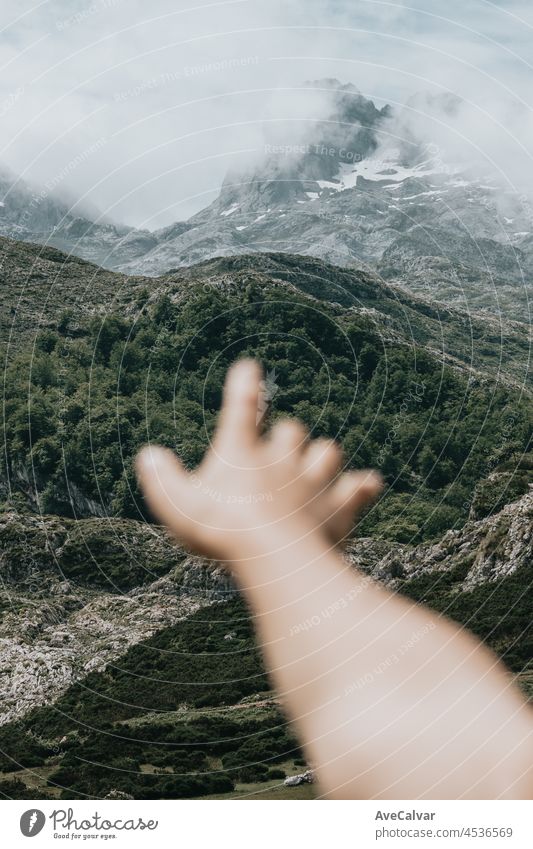 Moody Tapete einer unscharfen Hand vor einer bunten Landschaft der Berge von Asturien während eines sonnigen Tages, Covadonga Seen, friedliche Szenario, verschneite Berge, Kopie Raum