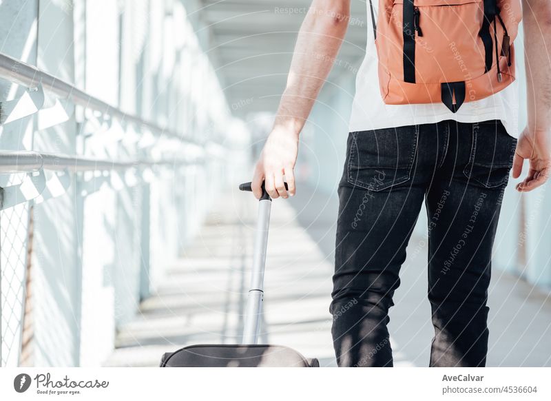 Zurück Schuss eines Reisenden trägt sein Gepäck und Taschen auf dem Flughafen oder Busbahnhof während einer Reise. Hipster modernen Reisenden, sonnigen Tag, Kopie Raum.