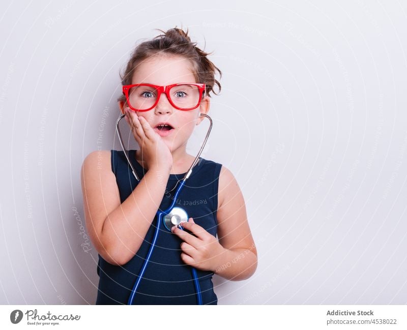 Erstauntes Mädchen lauscht dem Herzschlag Arzt Stethoskop Verkleidung spielen medizinisch spielerisch Kindheit Sanitäter erstaunt Überraschung Erstaunen