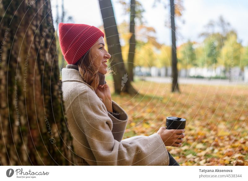Frau trinkt aus wiederverwendbarem Becher im Herbstpark trinken Tasse fallen Park Umweltschonung Erwachsener Lifestyle Person im Freien Natur eine Person