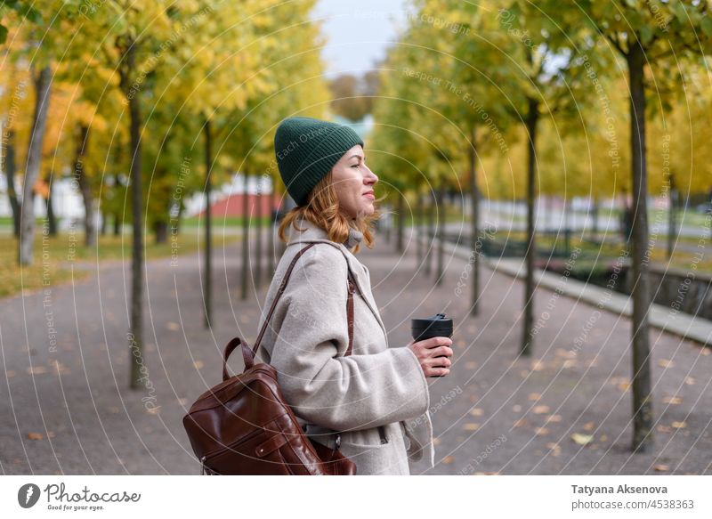 Frau trinkt aus wiederverwendbarem Becher im Herbstpark trinken Tasse fallen Park Umweltschonung Erwachsener Lifestyle Person im Freien Natur eine Person
