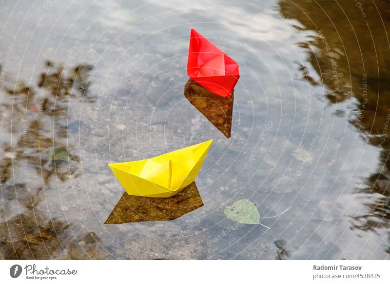 zwei bunte Papierboote schwimmen auf einem Bach Origami Schiff im Freien Saison Park Fluss klein Natur niedlich strömen Boote Frau wenig Spaß Zusammensein