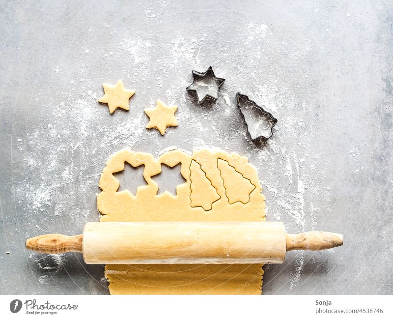 Ein ausgerollter Keksteig auf einem grauen Tisch Weihnachten backen Weihnachten & Advent roh Nudelholz Tradition Ausstechform süß draufsicht Winter Kindheit