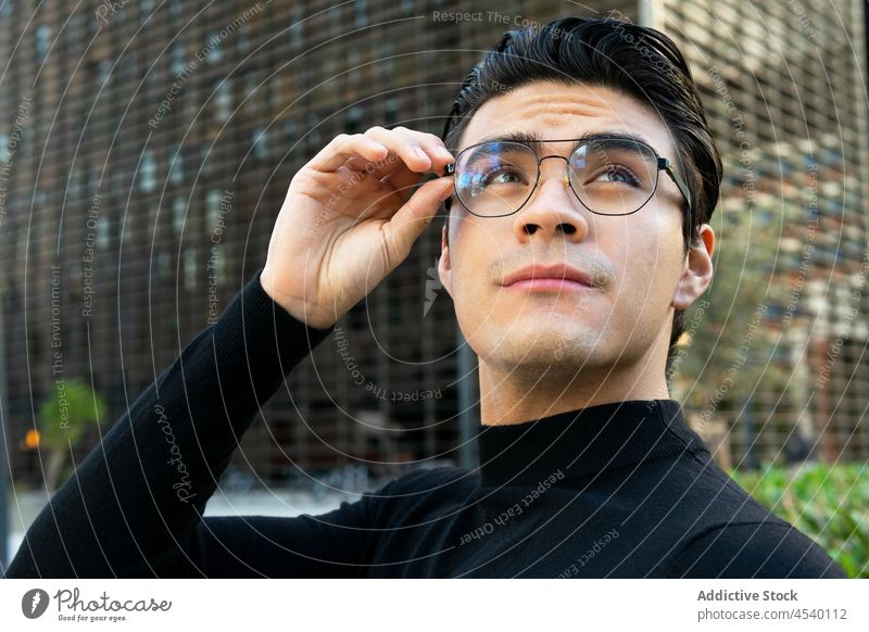 Asiatischer Mann mit Brille auf der Straße Gebäude Großstadt Stil urban modern Vorschein respektabel Outfit asiatisch ethnisch Bekleidung trendy Typ männlich