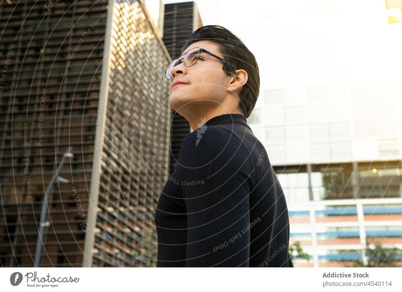 Asiatischer Mann mit Brille auf der Straße Gebäude Großstadt Stil urban modern Vorschein respektabel Outfit asiatisch ethnisch Bekleidung trendy Typ männlich