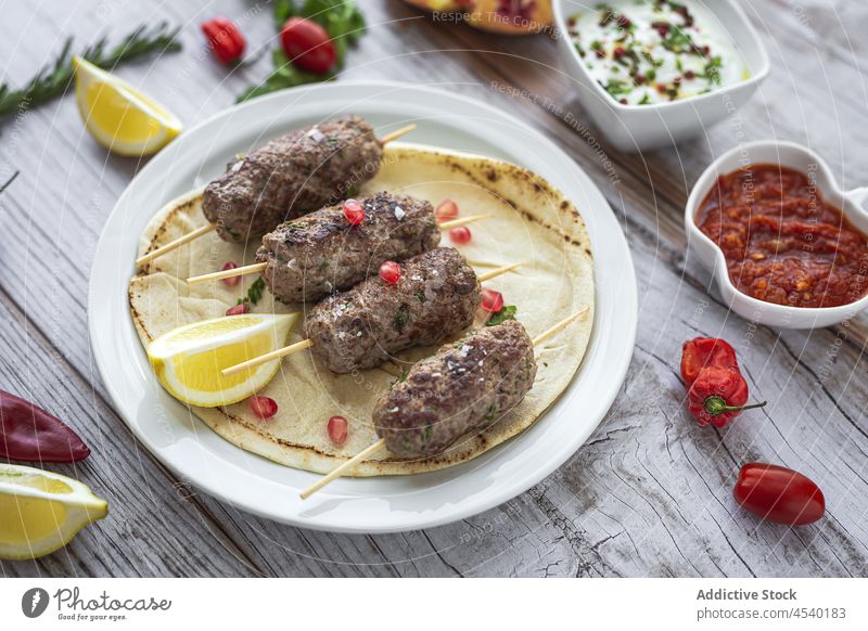 Traditionelle hausgemachte Kafta- oder Kofta-Spieße mit Tomatensauce und Joghurt Lamm Kefta Gewürze Kebab Halal-Lebensmittel halal Hintergrund