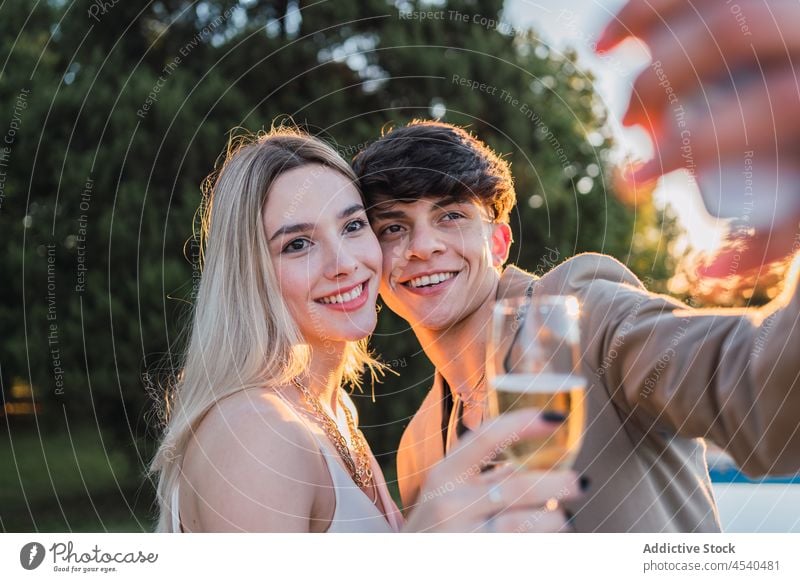 Paar nimmt ein Selfie im Park heiter Alkohol Zusammensein Smartphone Funktelefon Champagne Selbstportrait sorgenfrei benutzend Kälte Bonden sich[Akk] entspannen